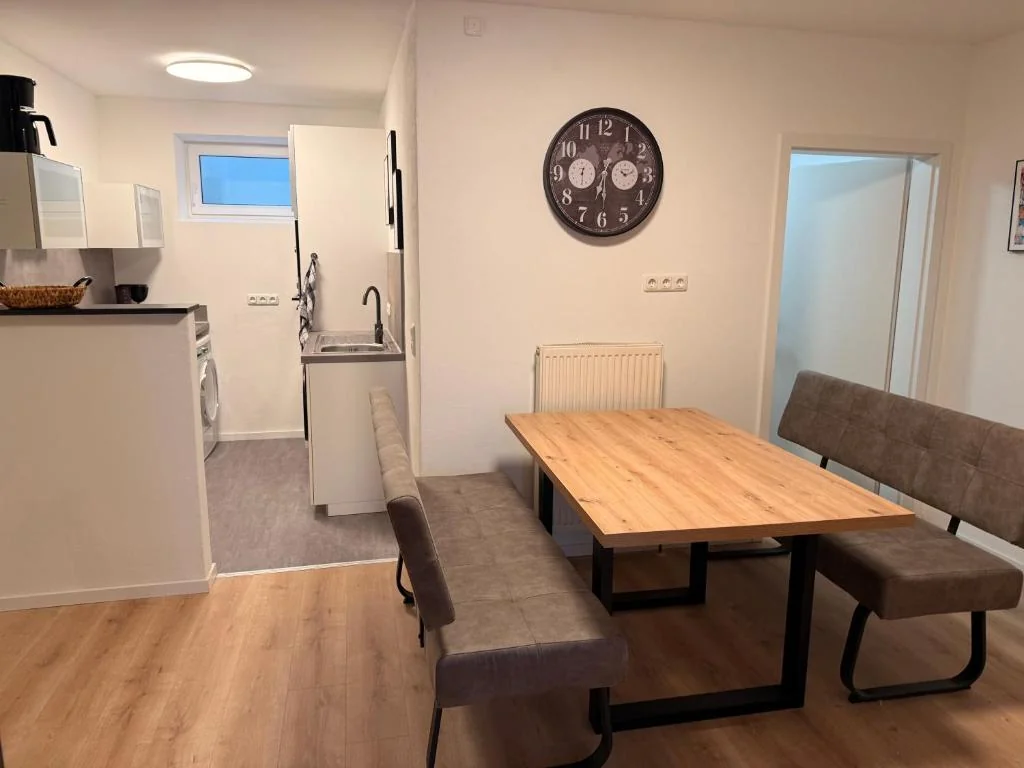 Essbereich mit Holztisch und angrenzender Küche — Casa Daniela Residence