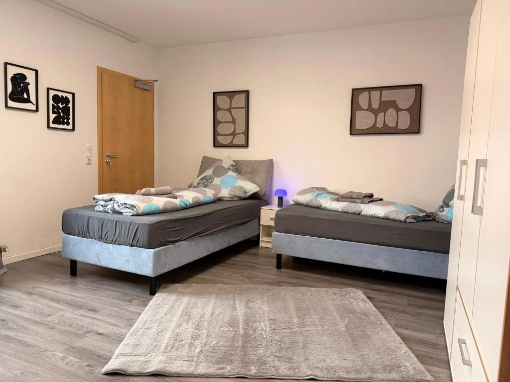Schlafzimmer mit Einzelbetten und Teppich — Casa Daniela Residence